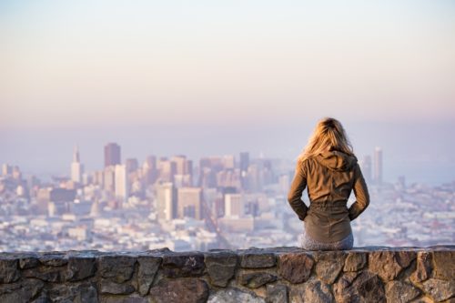 Girl sitting in front of city-scape